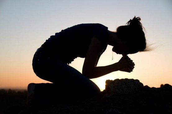 woman bowing in prayer